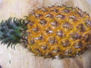 3、版纳香甜糯萝饭,取一个凤梨冲洗表皮