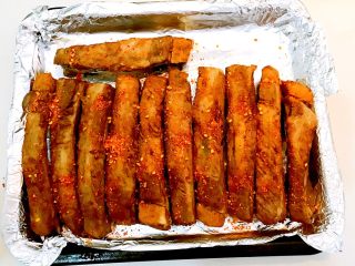 15、东北风味  密制香辣大肋排,把烤盘取出来，在排骨上面均匀的撒一层辣椒粉