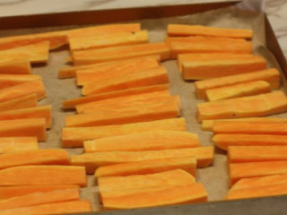 2、【桂花蜂蜜红薯条】,红薯削皮切细条，放在烤盘上