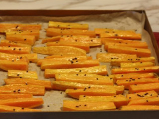 5、【桂花蜂蜜红薯条】,取出烤盘，再扫一层黄油，撒些黑芝麻