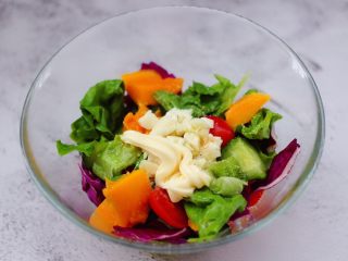 13、蒜香沙拉时蔬水果,碗中挤入沙拉酱,用筷子搅拌均匀即可。