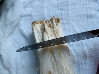 6、粉丝蒸金针菇,先将金针菇根部切下来；