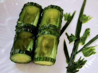 13、清新养眼的翠竹报春,摆放在盘子中,用黄瓜皮做两根竹子做装饰,再用黄瓜皮剪出叶子,装饰竹子上。