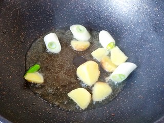 2、超简单家常版~香菇黄焖鸡,锅中放油烧热,放入姜和大葱炒香。生姜也可以拍碎。大葱也不要切的太碎,