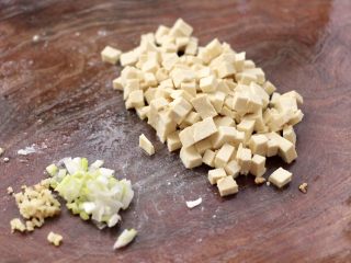 3、萝卜樱海鲜豆腐蒸饺,把老豆腐用刀切成小碎丁,葱姜切碎。