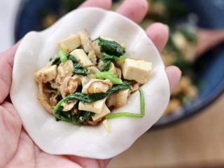 13、萝卜樱海鲜豆腐蒸饺,饺子皮上放入适量的馅料。