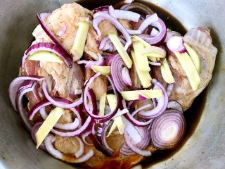 5、烤羊腿,调味料均匀的涂抹在羊腿上将切好的圆葱和姜摆入羊腿中盖上保鲜膜放入冰箱冷藏25小时煨制入味