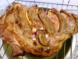 11、烤羊腿,羊腿烤至半熟取出刷上一层油再将剩余的调味料均匀的涂抹在羊腿上放入烤箱继续烤30分钟