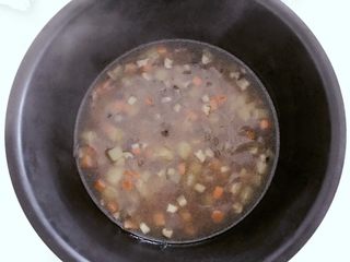 7、宝宝辅食：有饭、有菜、有肉，啥都有的土豆牛肉焖饭！18M+,把浸泡好的大米放入电饭锅，倒入步骤9的所有食材和汤料，并且翻拌均匀，按下电饭锅煮饭模式就可以了。