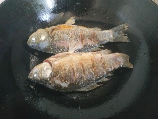 5、酱焖鲫鱼,锅中放入适量植物油，放入鲫鱼，两面炸至金黄盛出待用