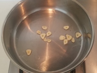 4、泡菜锅,锅里倒一大勺食用油用中火加热，放入蒜片煽炒出香味。