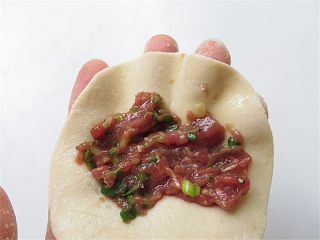 9、羊肉煎饺,在面皮上放上适量的羊肉馅，两边对起来捏齐