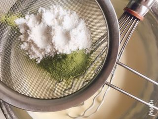 5、雪域抹茶芝士蛋糕,筛入抹茶粉和低粉，继续搅拌，此时出现颗粒是正常的