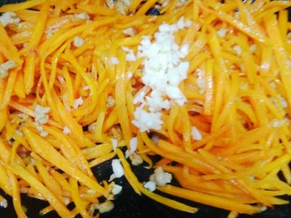 12、胡萝卜炒肉丝,放入蒜末翻炒。