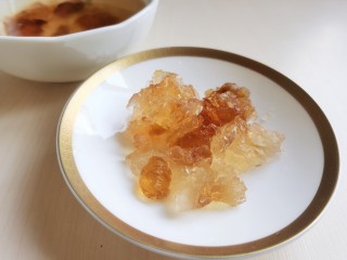 3、糖水鸡蛋,仔细将泡软的桃胶表面上的黑色杂质去掉，然后冲洗干净。