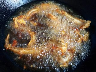 4、酥炸小鲶鱼,炸至小鲶鱼慢慢飘起来就用筷子翻动一下再继续炸