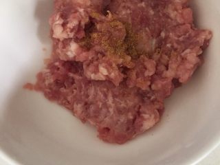 2、云吞面,盛入碗中，加入少量盐，鸡精，生抽，十三香，清水，顺时针搅拌均匀，直到猪肉吸收完水分
