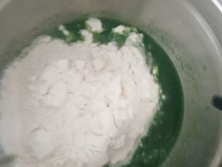 5、手擀菠菜面片,倒入面粉,边倒边搅