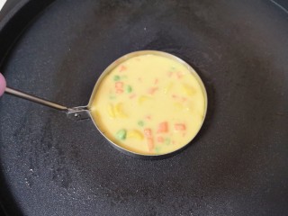 7、鸡蛋玉米饼,电饼铛预热（只开下盘），刷上一层玉米油，煎蛋模具里面也刷上一层食用油，放入电饼铛一起预热，预热完成以后，舀一勺玉米鸡蛋糊倒入煎蛋模具里面。