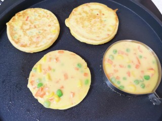 8、鸡蛋玉米饼,等到鸡蛋糊凝固以后，将煎蛋模具取开，饼翻面煎另一面，继续做下一个玉米鸡蛋饼。