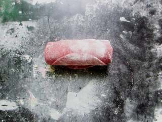 5、十味 玫瑰花馒头,从最下面的那个面片开始卷起。卷好后，来回搓几次，使每个面片之间的空气排出，粘合牢