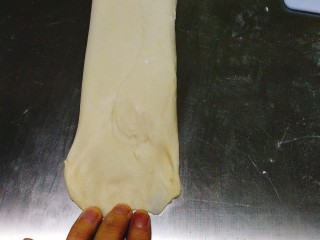 13、奶香吐司,翻面 把尾部拉宽，用手指按压薄