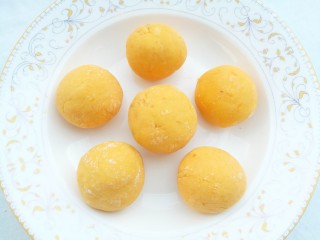 10、南瓜紫薯饼,将南瓜揉成面团分成6份揉圆后压扁。