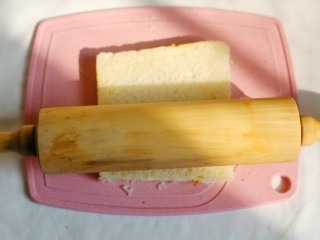 3、无敌简单的香蕉土司卷,用擀面杖滾成薄片。