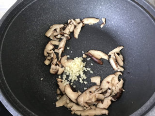 6、香菇炒青菜,炒至香菇片变软，加入蒜末炒香；