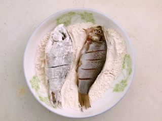 11、干炸鲫鱼,把腌制好的鲫鱼逐一蘸上薄薄的一层面粉