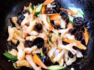 8、风味蹄筋,放入配料黄瓜和胡萝卜片、木耳同时放入盐和味精翻炒均匀