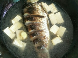 2、简手鲫鱼豆腐汤,加入适量的水，放入备好的白豆腐和姜片(按一人两碗水的分量，个人不太喜欢姜味，所以就放了两小片)