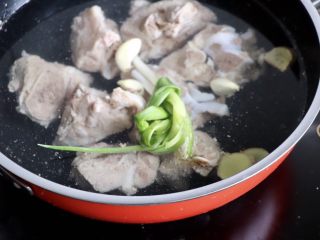 5、筒骨玉米冬瓜汤,另起锅把筒子骨放进去,放葱姜蒜,加适量的开水没过筒子骨,大火烧开,小火焖