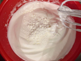 6、草莓蛋糕,把剩下糖和玉米淀粉加进去，搅拌几下再低档打发，直到搅拌均匀，用刮刀刮一下边缘的蛋白霜，再转档，打蛋器垂直对着蛋盆中间慢慢转圈圈搅打，为蛋白霜形成小气泡，把大气泡吸走，每打几圈都要提起来看看尖勾状态，千万不要打发过度！