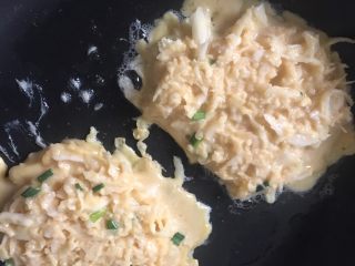4、香煎萝卜丝饼,4️⃣ 锅中油烧热，因为早饭不能吃太多油腻的食物，所以我就做成了煎饼。大致分成2个差不多大小的饼状，小火慢慢煎至底部微微焦黄再翻面继续煎至底部金黄。