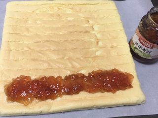 18、什锦果酱蛋糕卷,再用一张烤盘纸，蛋糕铺在纸上，表面放入什锦果酱。