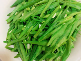 8、爆炒豆角,捞出豆角丝放入碗中。