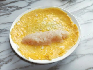 9、#辅食计划#蒸出来的虾肉鸡蛋卷,煎好的蛋饼铲出，放上麟虾肉，整理一下形状，之后从一面卷起。
