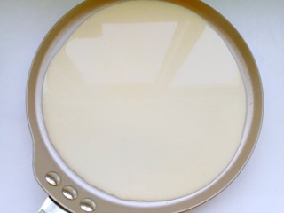 12、芒果千层蛋糕,迅速抬起平底锅，轻轻朝不同方向转动，使面糊均匀的摊开在锅底。