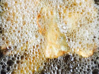 3、#年夜饭#干炸带鱼,锅里倒入适量的花生油烧热，把带鱼大火下锅定型后转小火炸至金黄