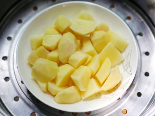 2、平底锅版奶香土豆饼,放入锅中蒸熟至软烂取出压成土豆泥。