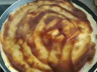 6、无油早餐鸡蛋煎饼灌饼,等饼皮完全成形后（翻面的时候饼皮不沾锅为佳，不要太软）小心地把饼皮翻面，抹上甜面酱。