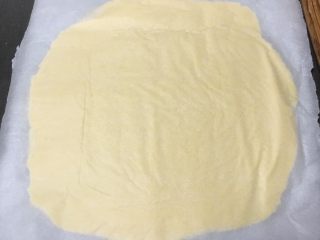 14、奶酪曲奇饼干,再覆盖一张烤盘纸，用擀面杖擀成正方形。