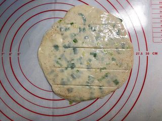 4、葱油饼,用擀面杖把饺子皮擀成饼胚，用刀在饼胚上轻轻划几刀。
