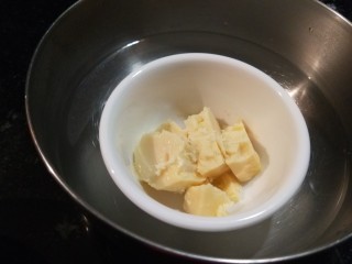 2、新文美食  自制烤箱板披萨,黄油放入碗中隔水融化。