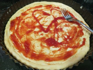 6、新文美食  自制烤箱板披萨,挤入番茄酱涂抹均匀。