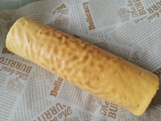 22、虎皮蛋糕卷,将提前款好的蛋糕体放入虎皮中间，用虎皮包裹卷起来，用油纸包紧定型几分钟