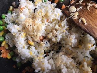 5、菠萝造型炒饭,倒入煮熟的米饭和虾皮，翻炒均匀