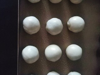 9、桃花酥,松弛好的水油皮，平均分成12份滚圆，备用，盖保鲜膜，全程都需要盖保鲜膜防止水份蒸发；