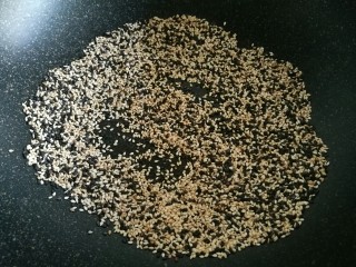 3、花生瓜籽麻糖,白芝麻和黑芝麻最好放入炒锅,用小火慢慢炒熟。注意别炒焦了。炒好后的芝麻和葵花籽(熟的)一起也放入烤箱保温。
